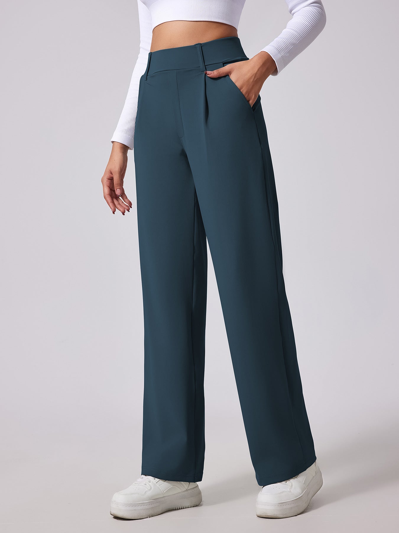 Teal wide-leg pants worn by a person on a light gray background