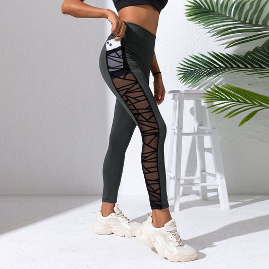 Person wearing black and gray leggings with sheer panels on a white background