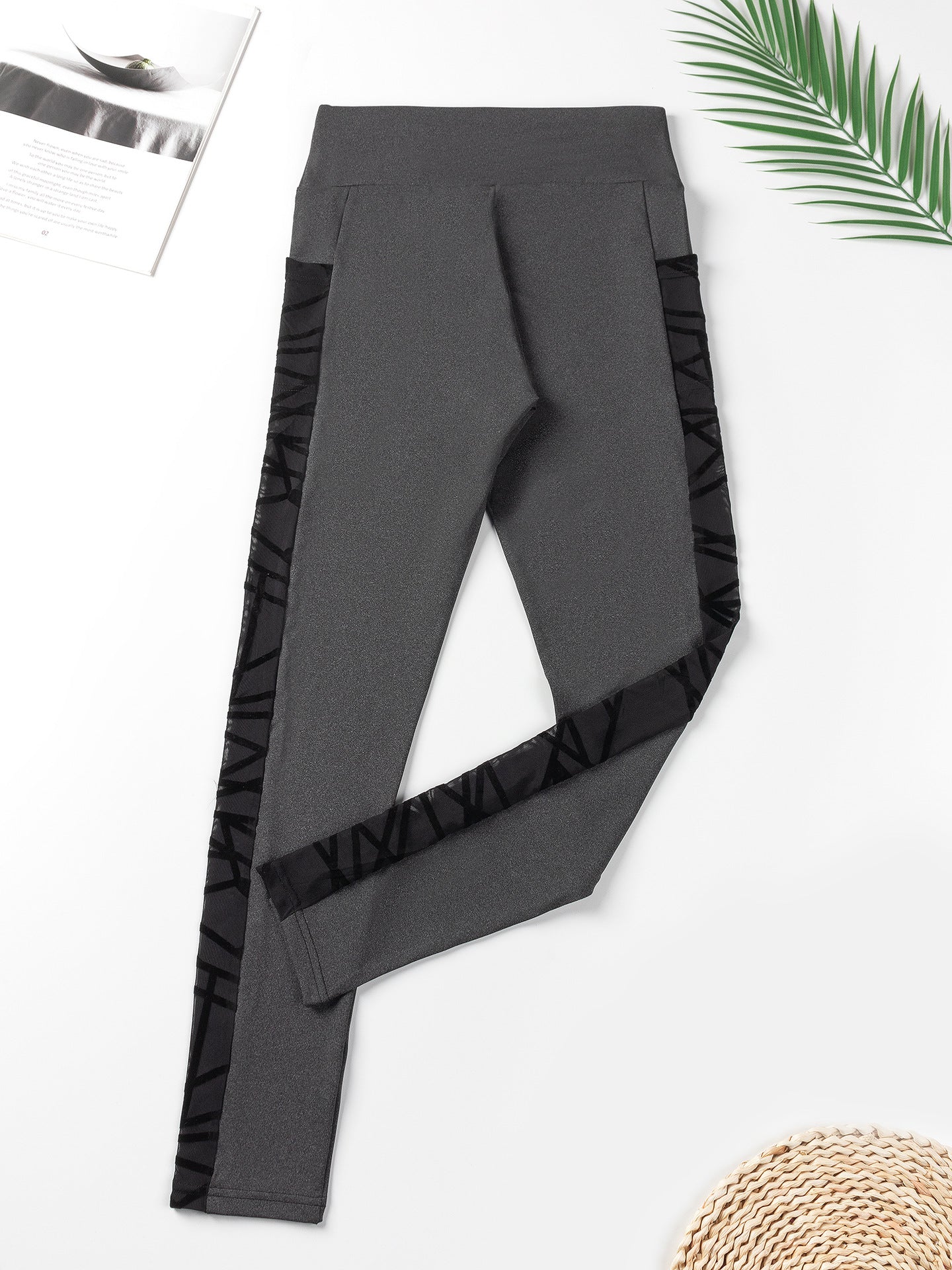 Gray leggings with black ruched sides on a white background