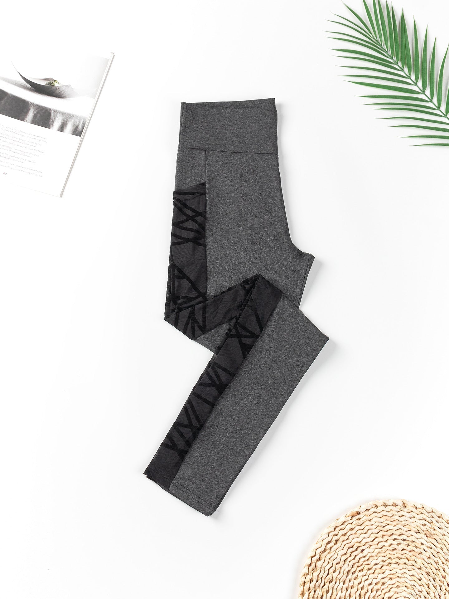 Gray leggings with black lace-up design on a white background