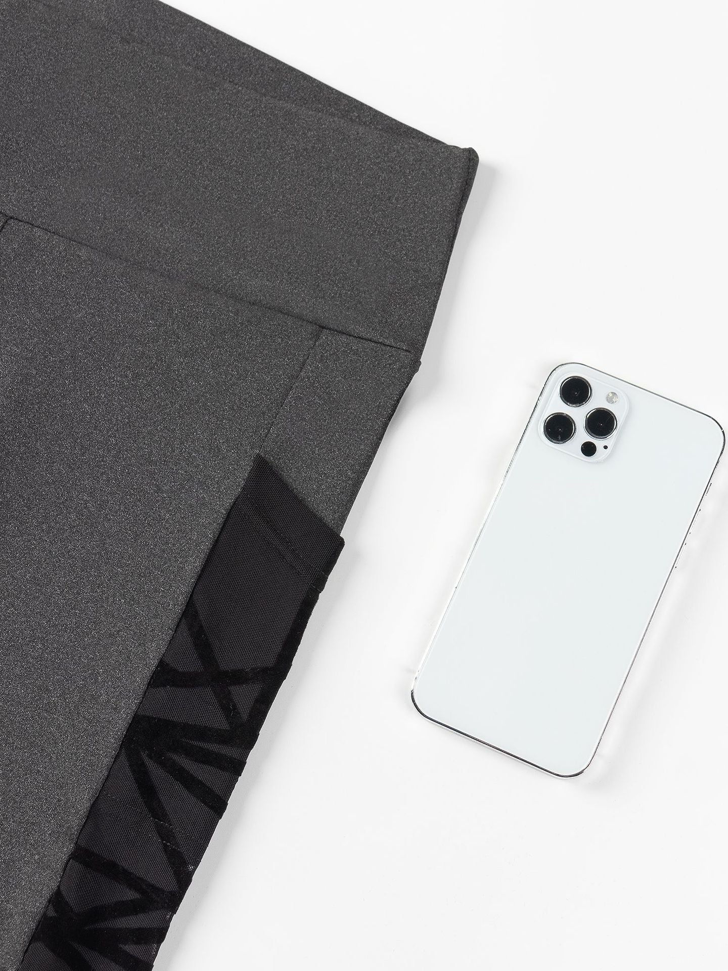 Smartphone on a white surface with a gray fabric background