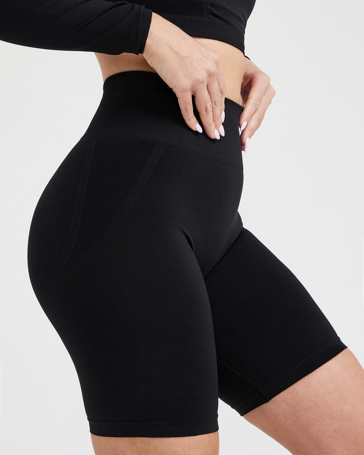 Black athletic shorts worn by a person on a light gray background