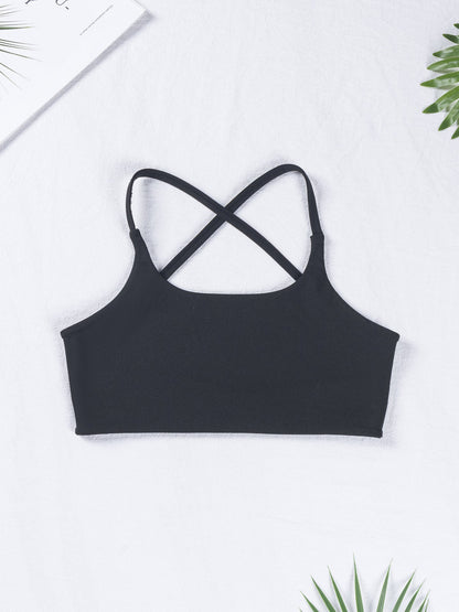Black crop top with criss-cross straps on a white background