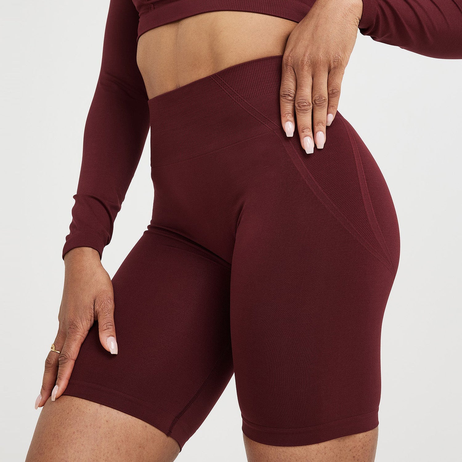 Maroon athletic outfit with long-sleeve top and shorts on a white background