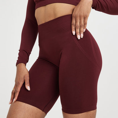 Maroon athletic outfit with long-sleeve top and shorts on a white background