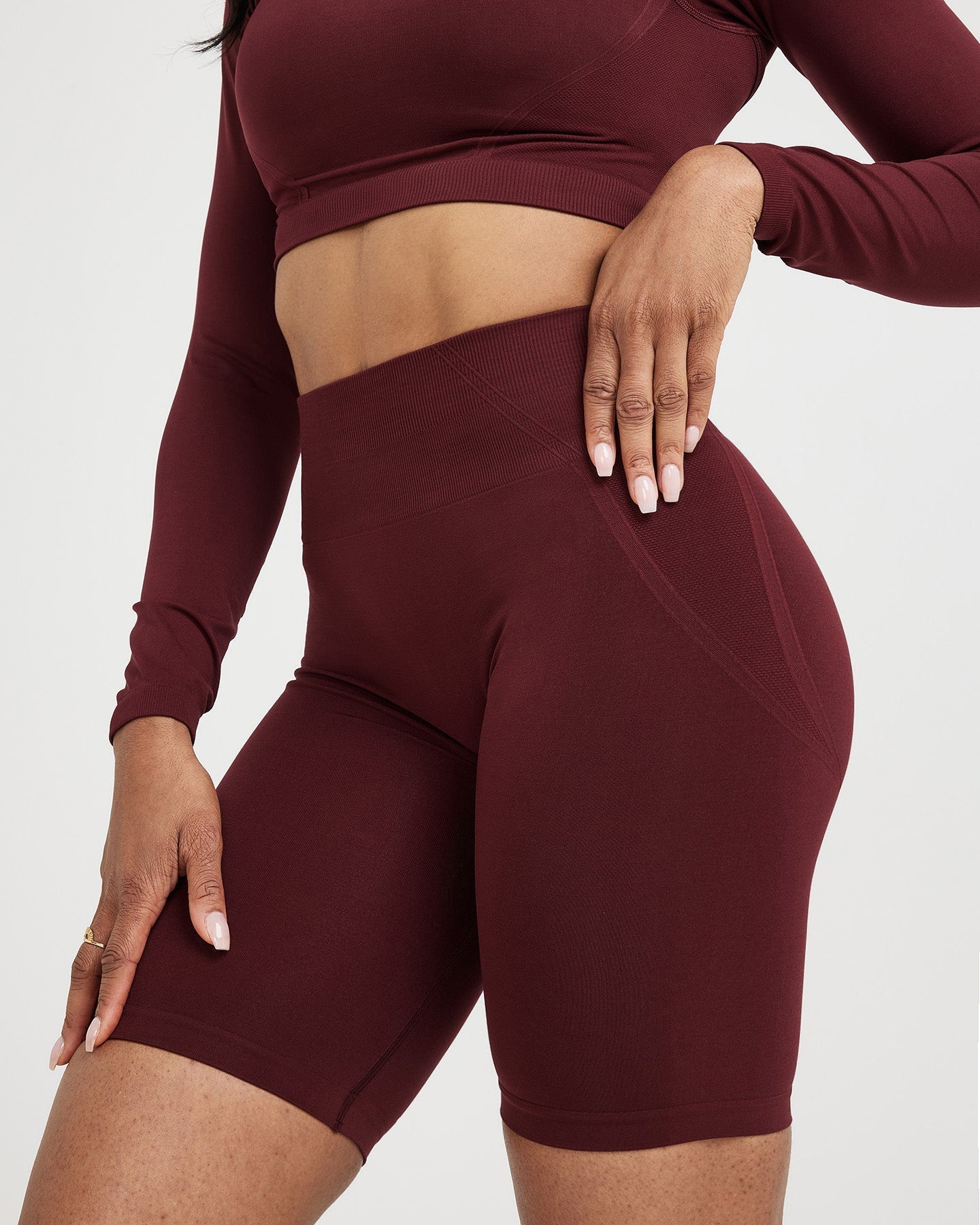 Maroon athletic outfit with long-sleeve top and shorts on a plain background