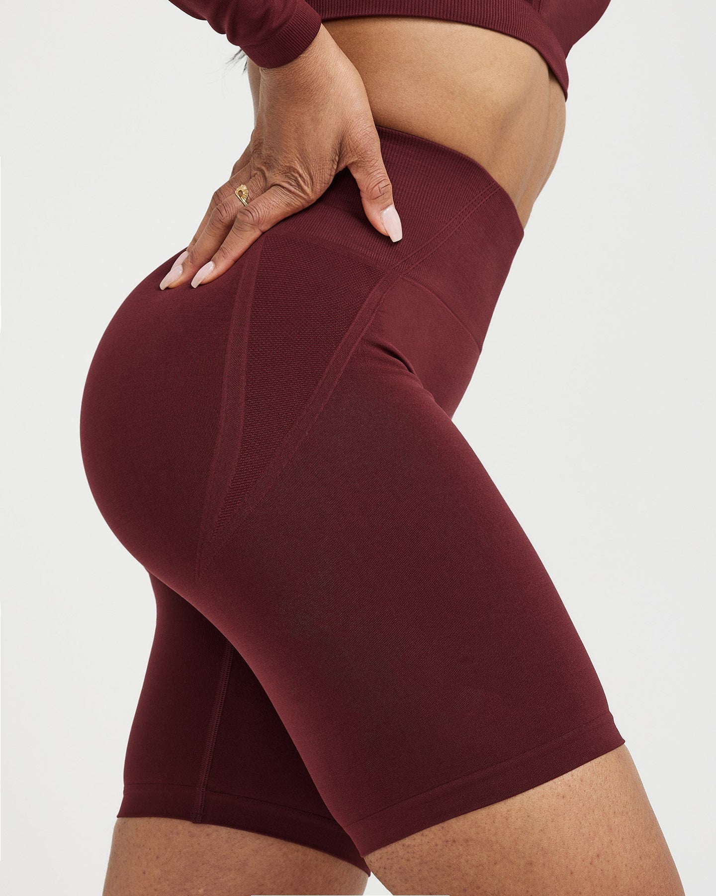 Maroon athletic shorts worn by a person on a white background