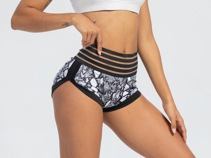 Person wearing a black and white patterned underwear set with a sheer panel on a light gray background