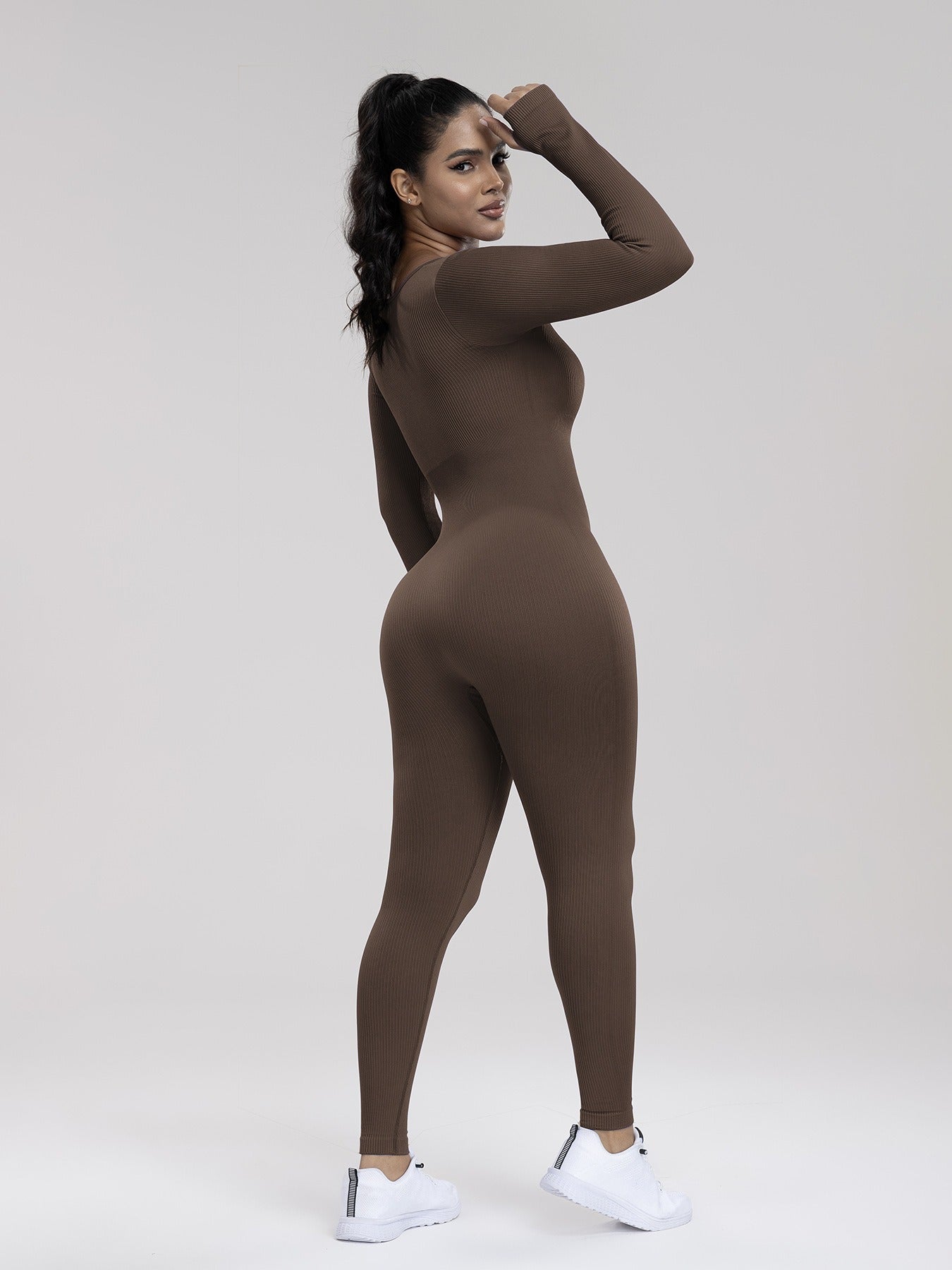 Person wearing a brown bodysuit on a white background