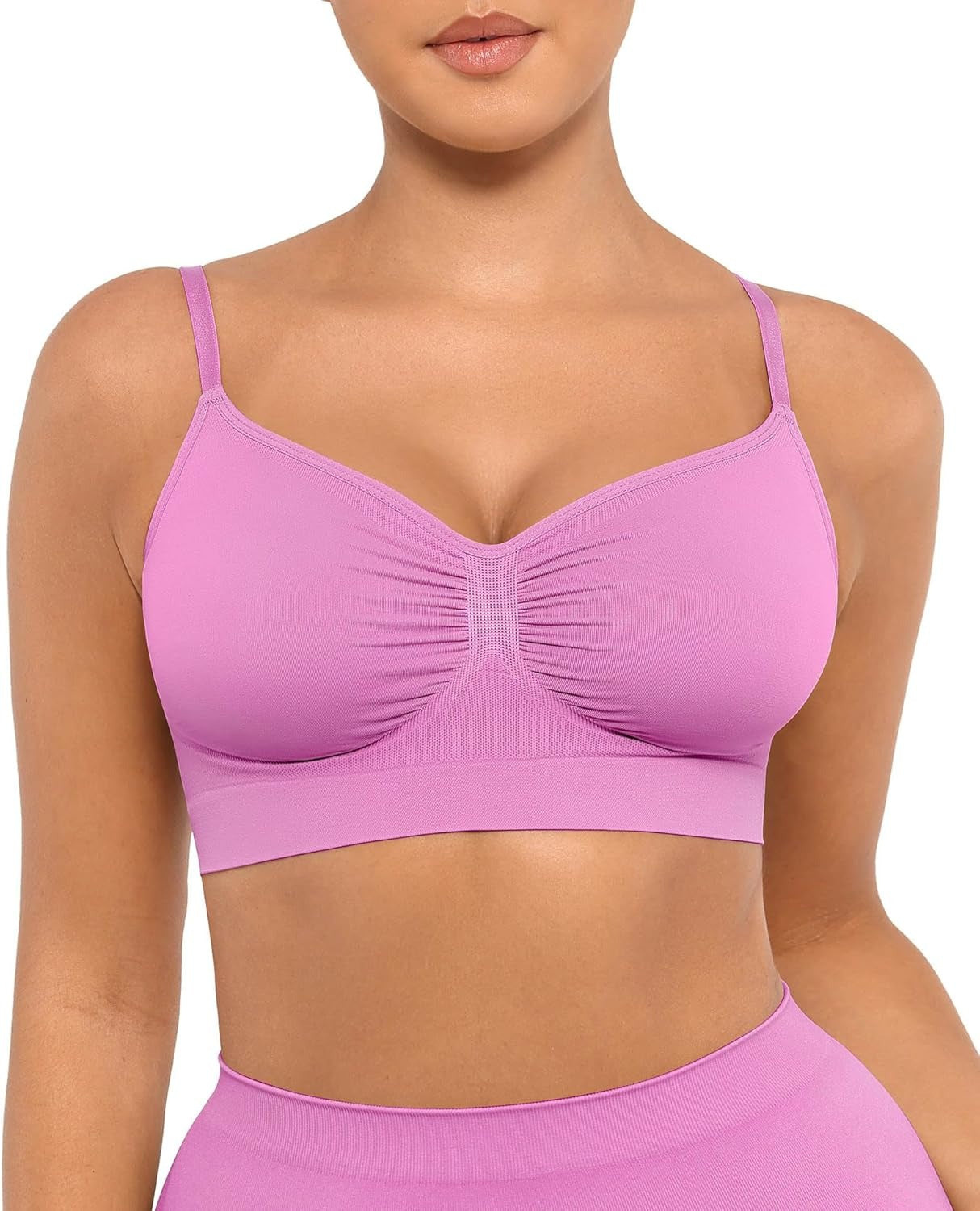 Pink sports bra worn by a person on a white background