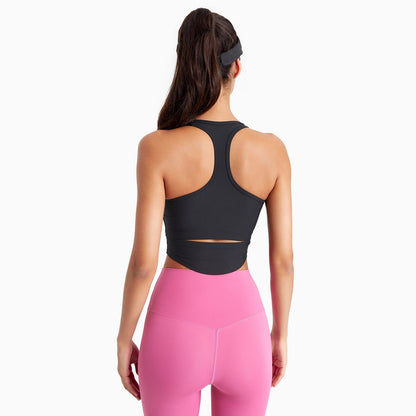 Woman wearing a black sports bra and pink leggings on a white background