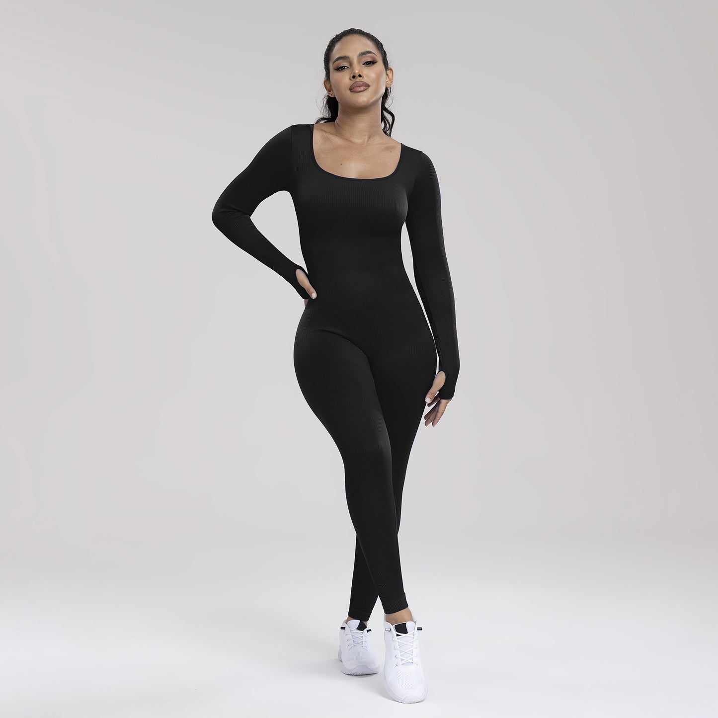 Woman wearing a black bodysuit on a white background