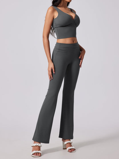 Woman wearing a gray sports bra and high-waisted leggings on a light gray background