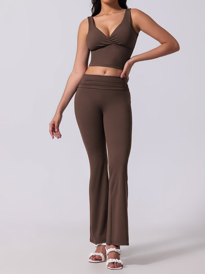 Woman wearing a brown sports bra and leggings set on a light gray background